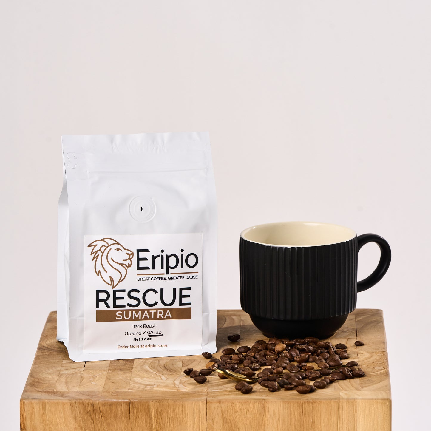 Eripio Rescue Sumatra coffee package with a black mug and scattered coffee beans on a wooden surface.