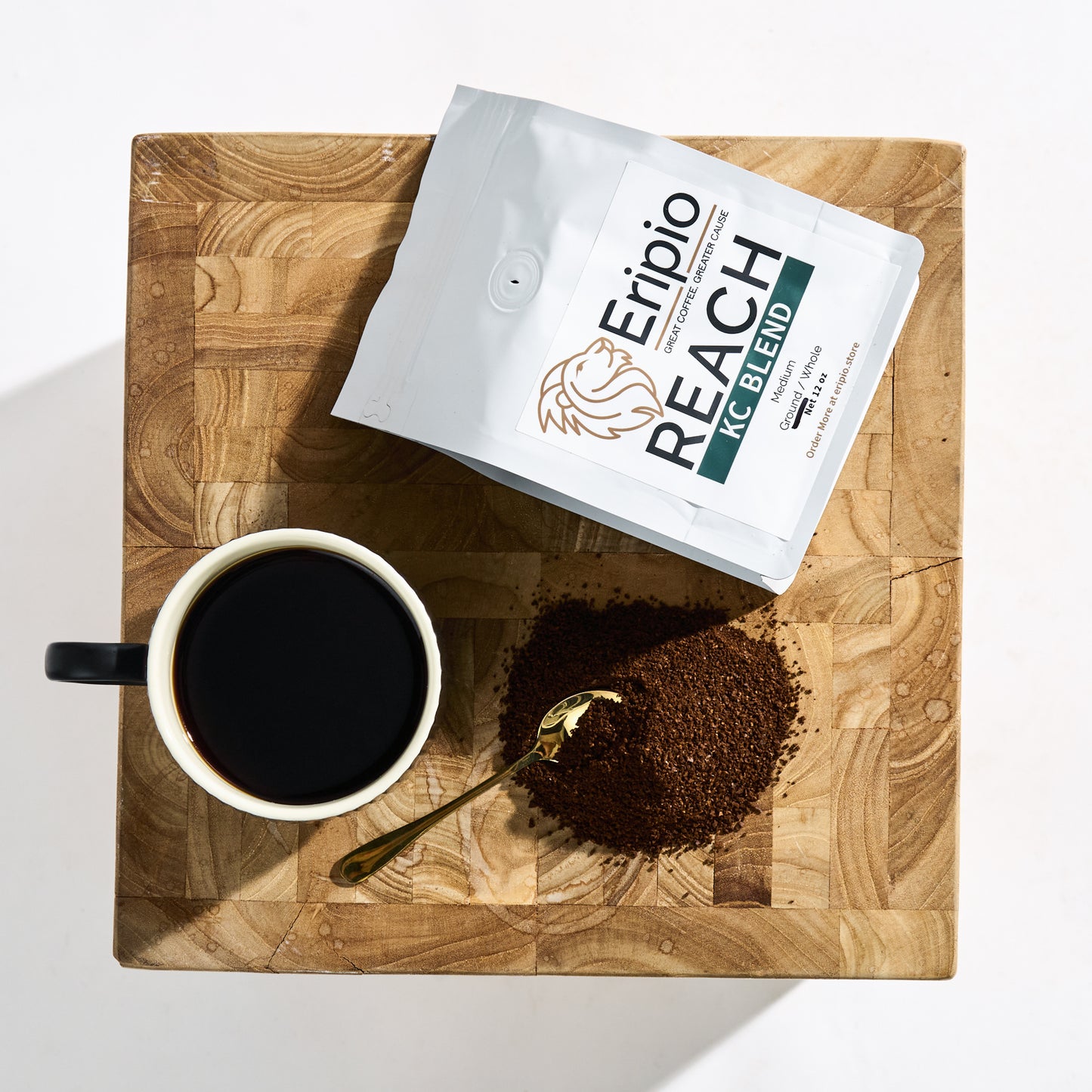 Eripio Reach coffee package on a wooden table with a cup of coffee and ground coffee.