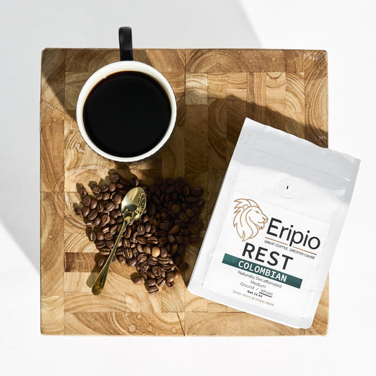 Coffee cup, coffee beans, and Eripio Rest Colombian coffee package on a wooden table.